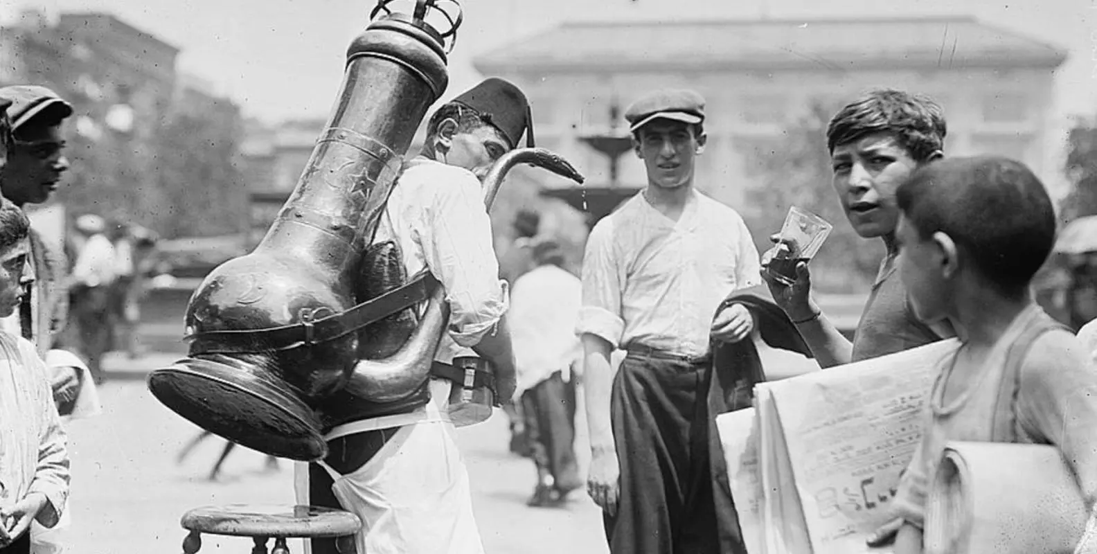 Black and white image of young newspaper vendors taking refreshments